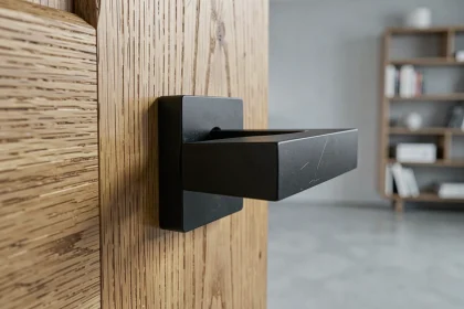 Poignée de porte noire matte design minimaliste sur porte en chêne dans un intérieur scandinave épuré